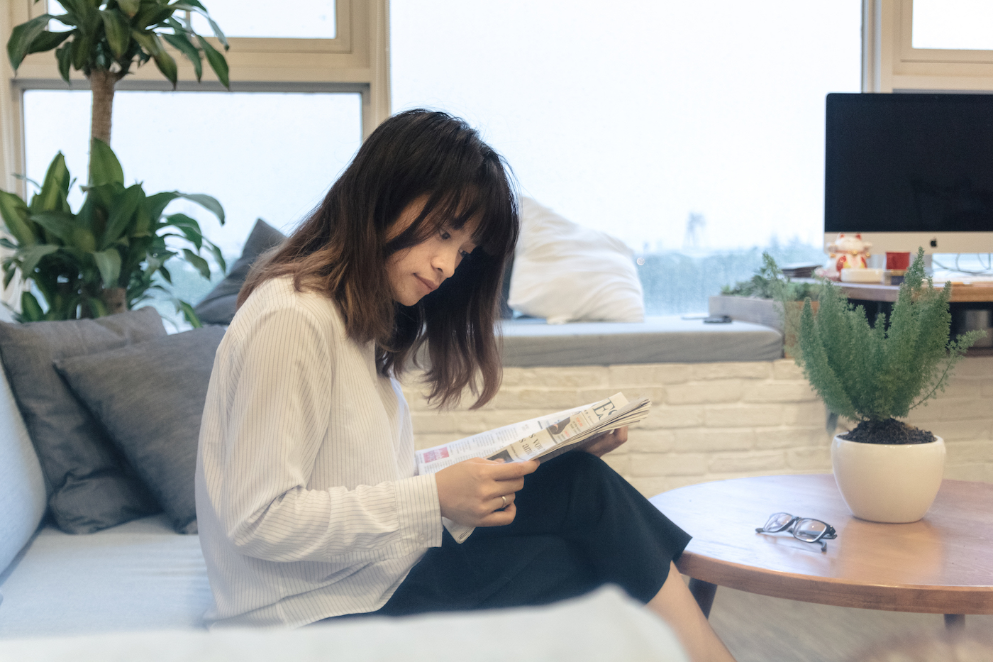 Young woman reading newspaper.